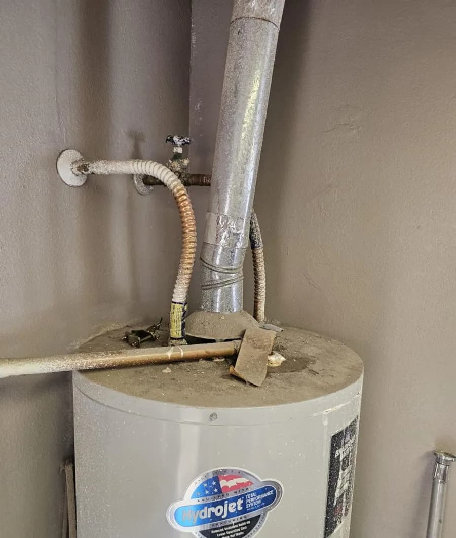 Aging gas water heater with corroded flex connectors and vent piping photographed on a JB service call
