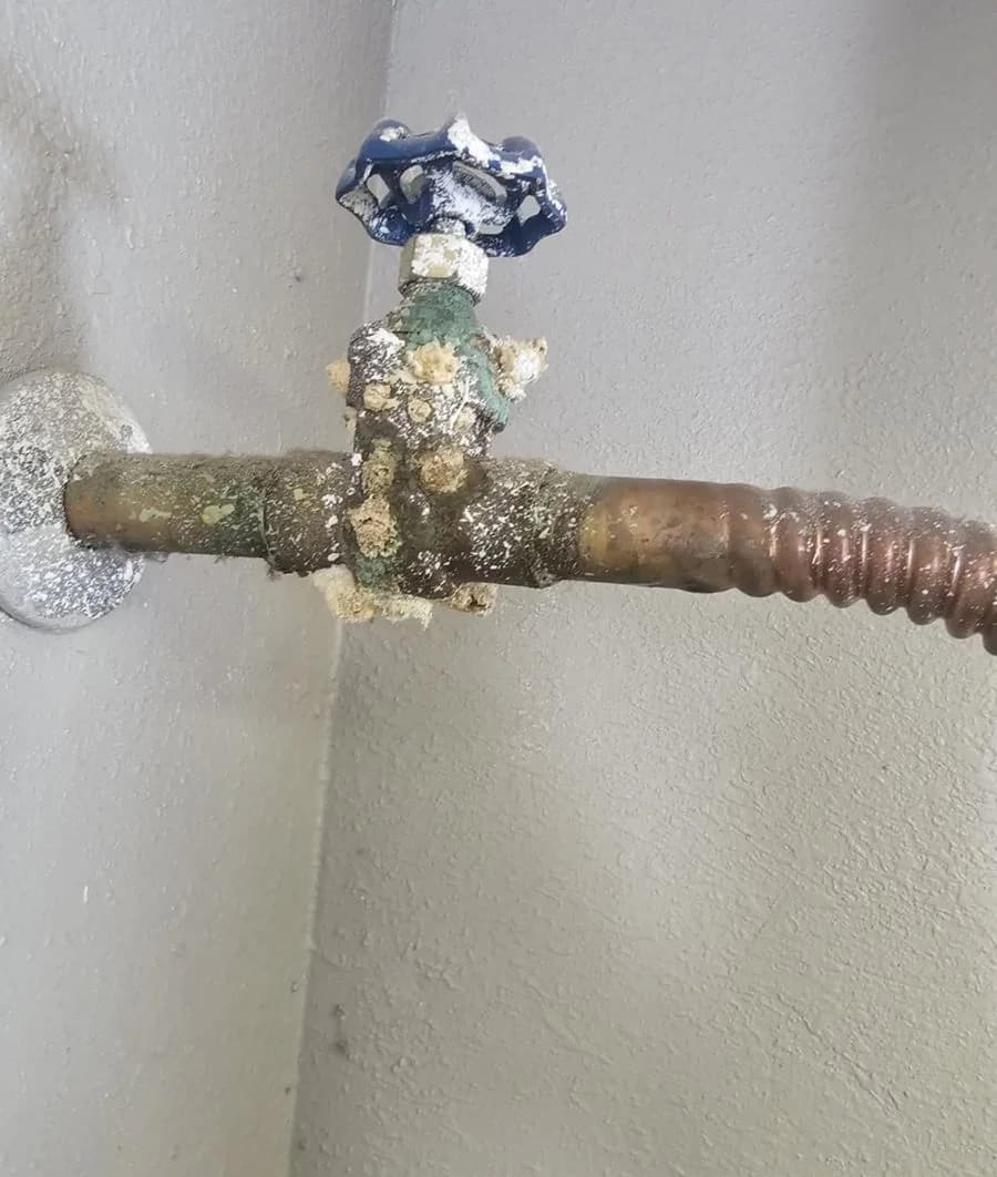 Heavy mineral scale and green corrosion on a copper shut-off valve photographed on a JB service call